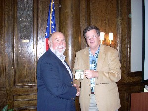 Capt. Bob Whitkop, USN (Ret) (r), chapter president, presents a Palm Tree Mug to Art Silcox in appreciation for his February visit and talk on satellite challenges and capabilities.